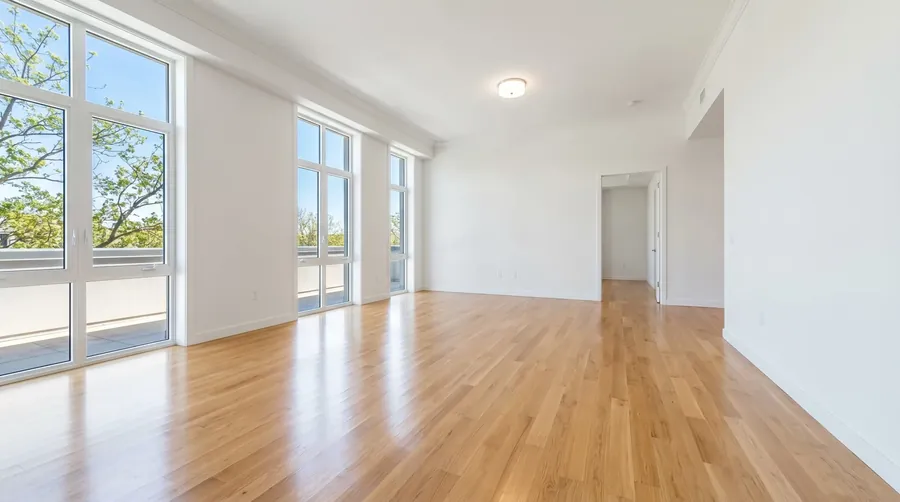 Newly cleaned modern living room with hardwood floors and large windows